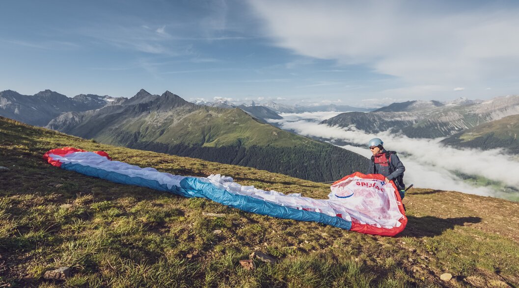 Vorbereitung Tandemflug beim Startplatz Jakobshorn | © Davos Klosters Mountains Der Pilot breitet den Gleitschirm beim Startplatz Jakobshorn aus und bereitet so den Abflug vor. | © Davos Klosters Mountains