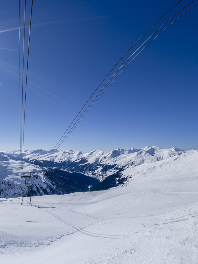 Sonnenstrahlen hüllen das weite Bergpanorama ein, | © Davos Klosters Mountains