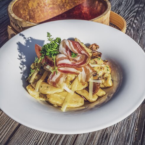 Ein währschaftes Gericht mit Speck und Kartoffeln ist auf dem Teller angerichtet. | © Davos Klosters Mountains