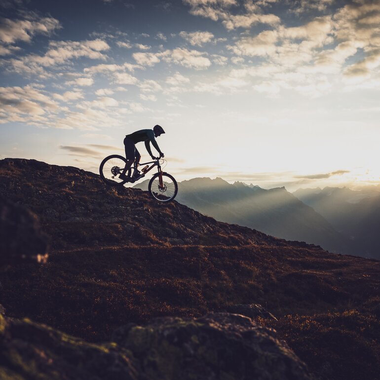 Der Biker fährt über den Grat auf Parsenn Gotschna und ist beim Abendlicht als Silhouette zu sehen. | © Davos Klosters Mountains