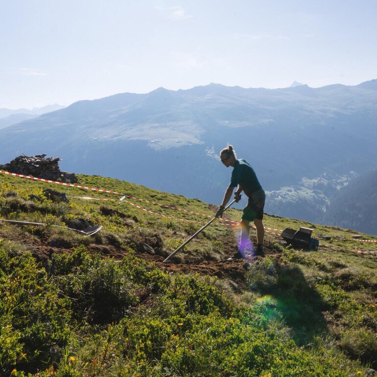 Person am Mülleinsammeln auf Wiese  | © Davos Klosters Mountains 