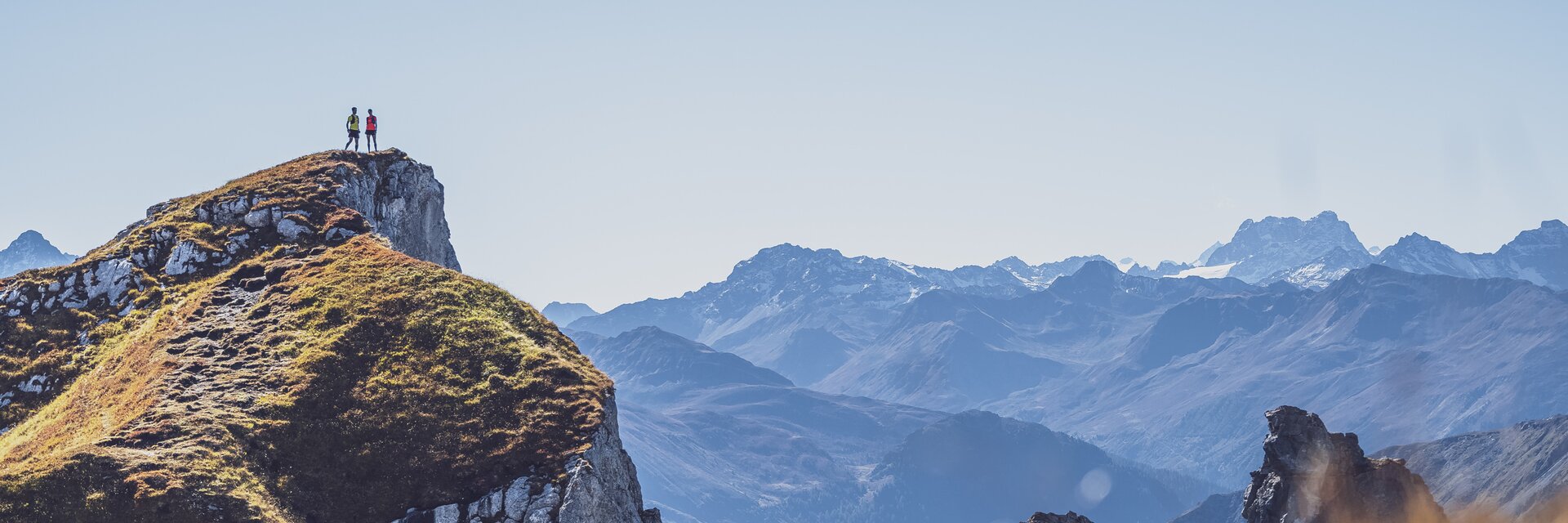Two trail runners stand on the Geisshorn and enjoy the beautiful panorama.  | © Davos Klosters Mountains