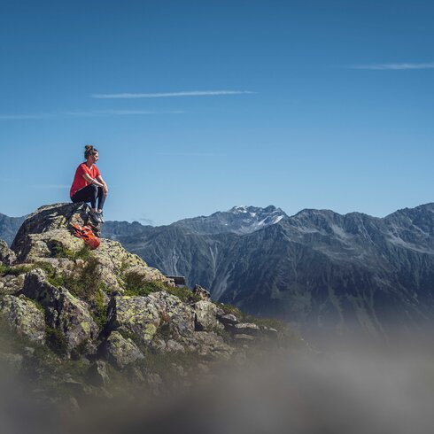 Person sitzend auf Felsen  | © Davos Klosters Mountains 