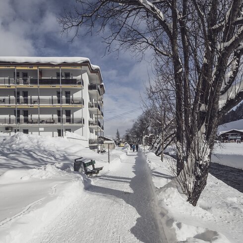 Winter hiking trail along the Landwasser valley, in the background a multi-storey building | © Davos Klosters Mountains 