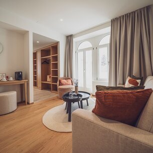 Helles Zimmer mit Garderobe, Salontisch und Couch | © Davos Klosters Mountains 