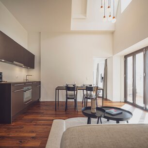 Helles Apartment mit Holzboden, Einbauküche, Esstisch und Couch | © Davos Klosters Mountains 