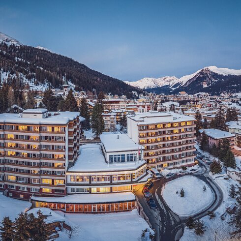 Illuminated Mountain Plaza Hotel in winter. | © Davos Klosters Mountains